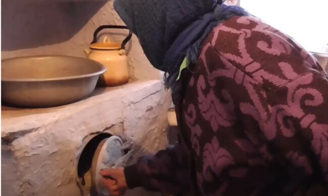 бабуся топить дровами, пенсіонерка, старенька
