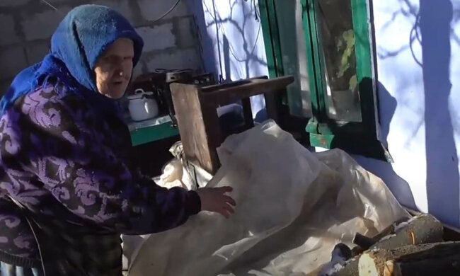 бабуся топить дровами, пенсіонерка, старенька